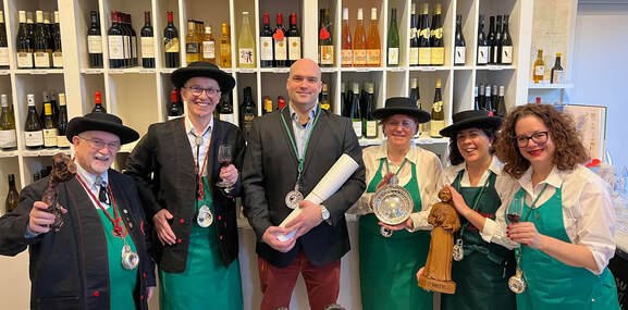 Photo of Le Maitres Compagnons with new inductee, sommelier Tucker Hurley at Le French Wine Shop. Featured from left to right are Master Sommelier Roger Dagorn, Chef Claude Godard, Tucker Hurley, Renee Pecot-Xenakis, Elisa Crye, Sommelier Suzanne Taylor